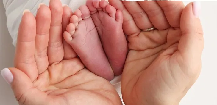 Babyfüße in den Händen der Eltern