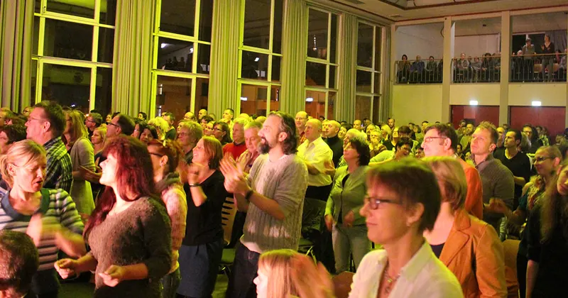 Publikum steht und klatscht beim Sing 4 Charity Konzert